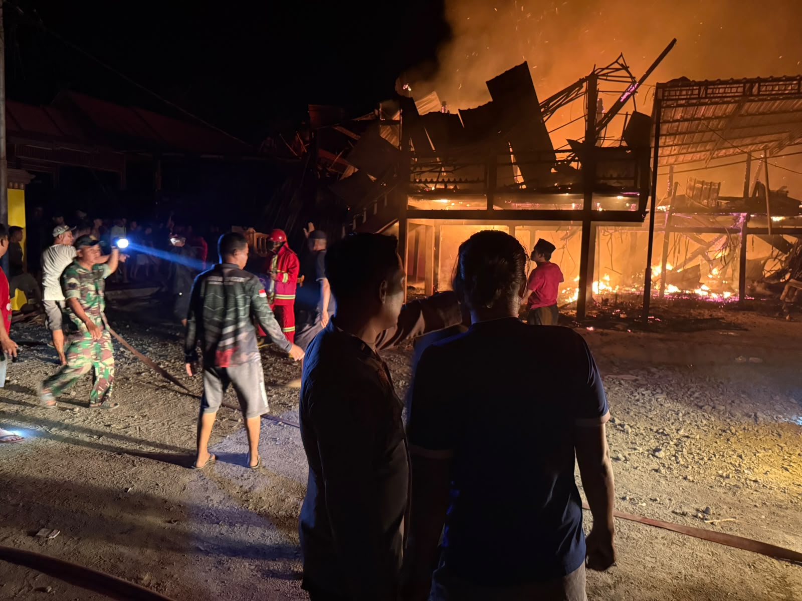 Petugas memadamkan rumah panggung yang terbakar di Pitu Riawa Sidrap.