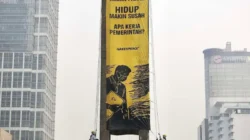 Cara 6 Aktivis Greenpeace Naik di Patung Bundaran HI Bentangkan Spanduk Kritik 2 Tahun Prabowo-Gibran